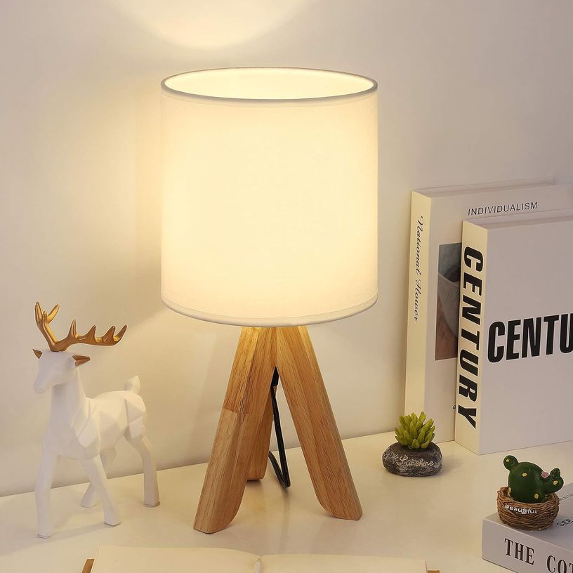 Small wooden tripod lamp with a white fabric shade.