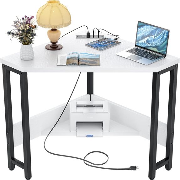 Small white triangle shaped corner desk with outlets and USB ports.