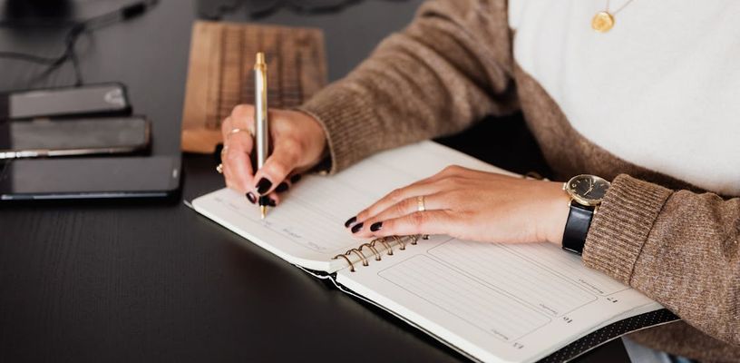 Stylish woman taking notes in notebook.